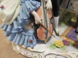 a figurine of a woman with a violin on a plate