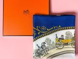 a blue and white purse with a horse drawn carriage on it next to an orange box