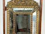 a mirror on a stand with a vase on top of it