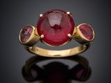 a close up of a gold ring with a ruby stone