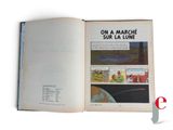 an open book on a white background with a picture of a space station in the background