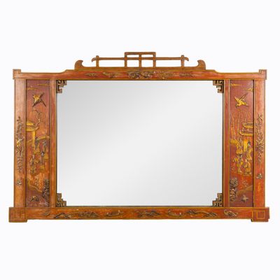 un grand miroir avec un cadre en bois orné d'un motif