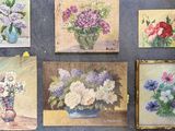 many paintings of flowers in a vase on the wall