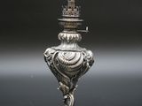 un bougeoir en argent surmonté d'une couronne