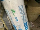 a large roll of insulation sitting on the ground next to a pile of wood