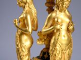 an image of a gold statue of two women holding a bowl