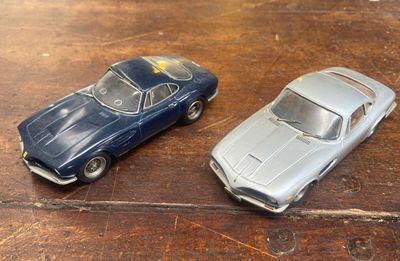 deux petites voitures posées sur une table en bois
