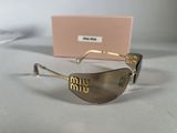 gold rimmed sunglasses with brown tinted lenses on a white surface