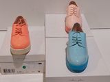 trois paires de chaussures exposées dans une boîte blanche