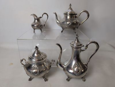three pieces of silver tea and coffee set on a table