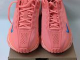 une paire de baskets Nike roses posées sur une boîte
