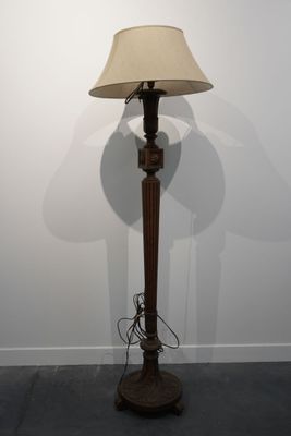 une lampe posée sur le sol à côté d'un mur
