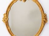 un miroir doré accroché au mur, sur fond blanc