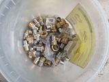 a lot of screws in a plastic container on the ground