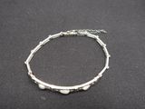 gros plan d'un bracelet en argent sur une surface noire