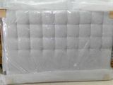 un matelas emballé dans du plastique et posé à même le sol