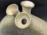 a stone vase with two smaller vases on it