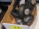 une boîte contenant plusieurs casques audio, posée sur un bureau