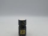 un petit flacon de peinture noire et dorée posé sur une surface blanche