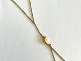 un collier plaqué or orné d'une boule en or suspendue à une chaîne en or
