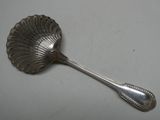 une cuillère ancienne en argent dont le manche en forme de coquillage se détache sur un fond blanc