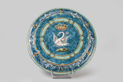 une assiette bleue sur laquelle est représenté un cygne, surmontée d'une couronne