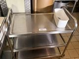 a metal table with a bucket on it in a kitchen