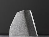 a close up of a concrete object on a table with a black background