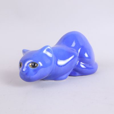 a blue cat figurine sitting on a white surface