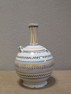 un vase blanc posé sur une table près d'un mur