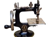 a black and silver sewing machine on a white background