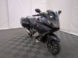 une photo d'une moto noire garée sur un sol à damier