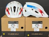 Deux casques sont posés sur des cartons, sur une table.