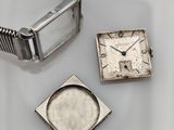 a silver watch and a square watch sitting on a table