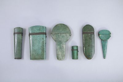 quatre pièces de métal vert sont disposées sur une surface blanche