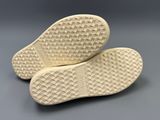 the soles of a pair of white shoes on a gray surface