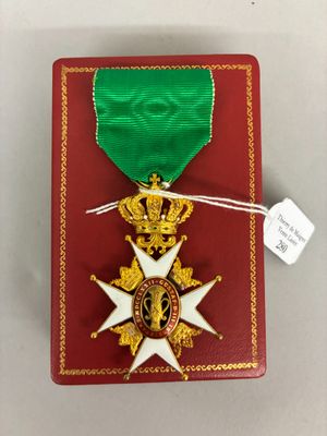 une image représentant une boîte rouge avec une médaille en or et un ruban vert