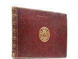 an old book with a gold emblem on the cover