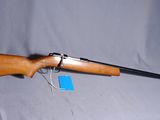 a rifle on a stand with a tag attached to it