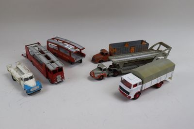 Plusieurs camions miniatures et camions sont alignés sur une surface blanche