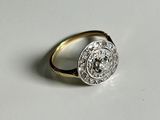 a close up of a gold and diamond ring on a white surface