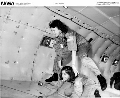 photographie en noir et blanc de deux femmes dans un avion en compagnie d'un chien