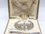 an antique silver plate with a spoon and spoon rest in a box