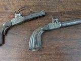 two old guns are sitting on a wooden table next to each other