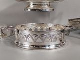 a silver plate with a bowl on top of it on a table