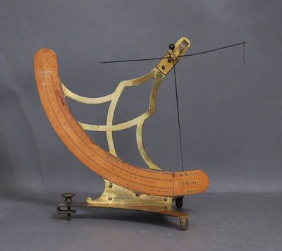 un objet en bois et en laiton posé sur un socle métallique