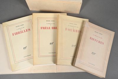 four books are sitting on a table with a box in the background