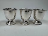 three silver cups sitting on top of each other on a table