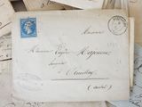 a pile of old letters and envelopes sitting on a table