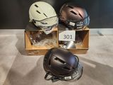 three helmets sitting on top of a cardboard box on top of a floor